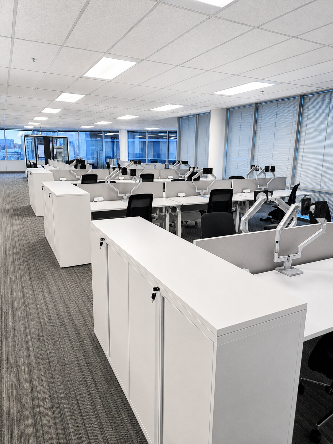 Modern open-plan workstation installation with white desks and integrated storage